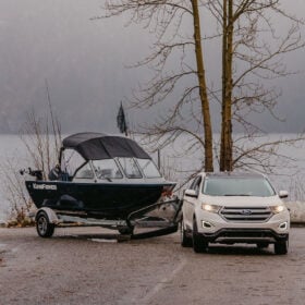 KingFisher 16 Falcon being towed by SUV on boat trailer with lake in background